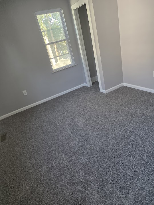 Empty room with gray carpet and white baseboards